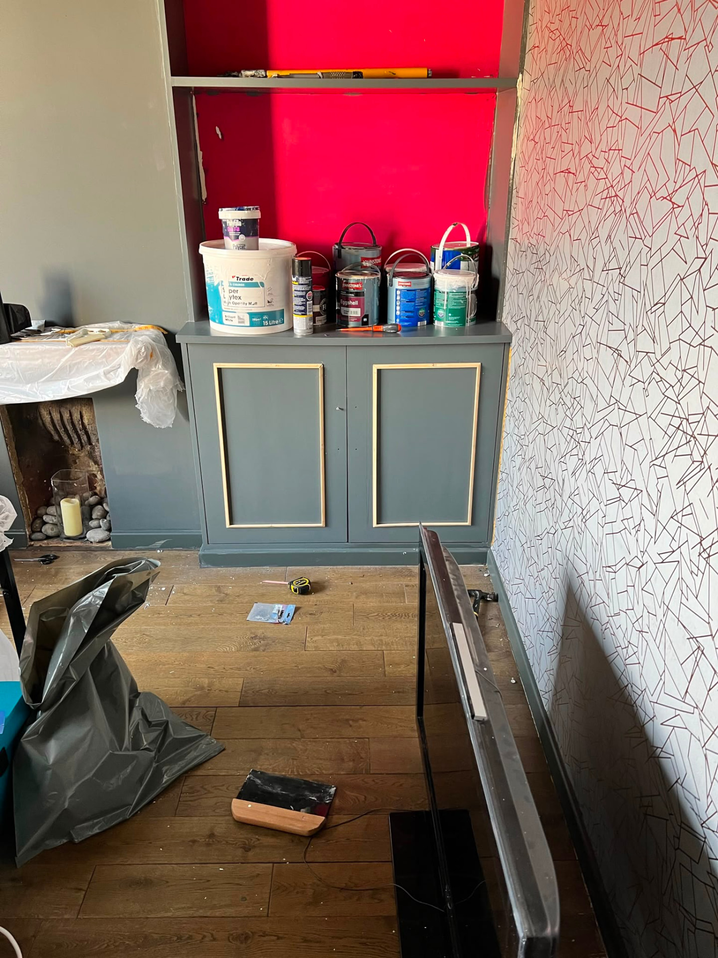 A room mid-decoration with painting supplies and furniture set aside.
