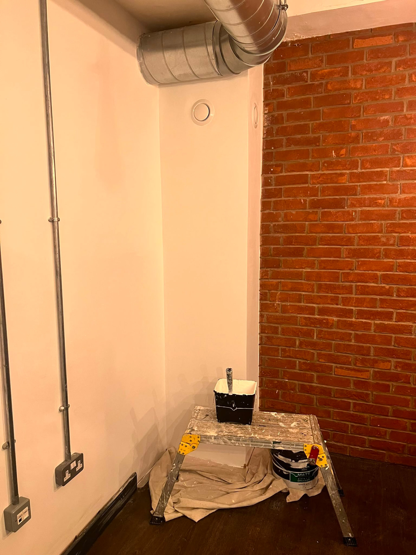 After: the same corner fully skimmed and decorated in white.
