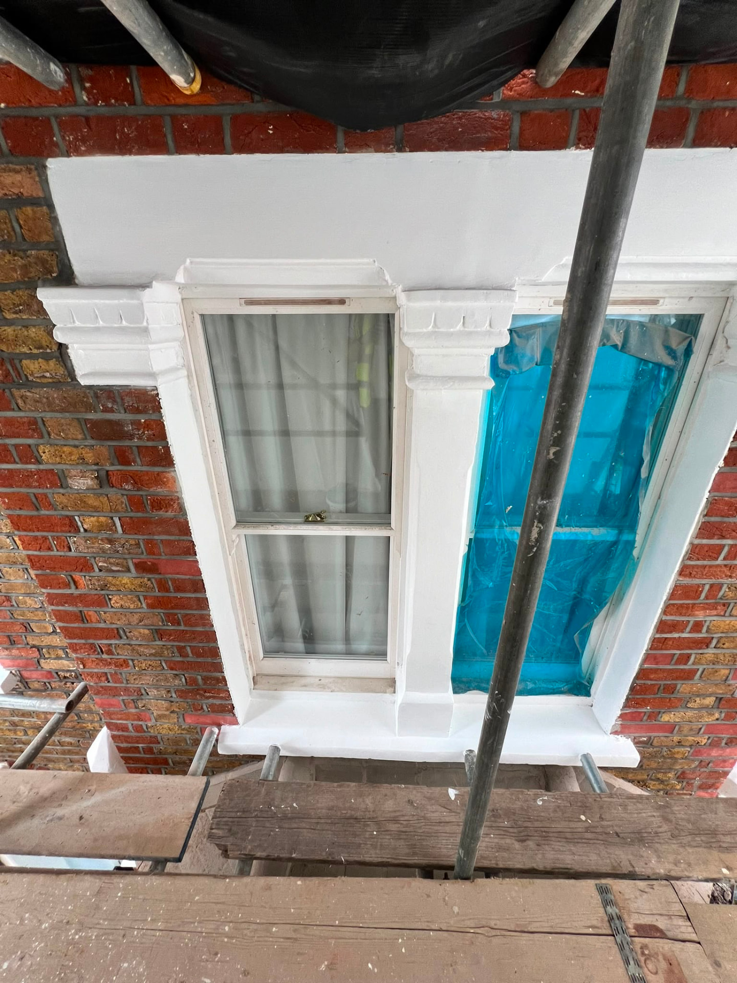 After: the arched window frame freshly painted white with the glass still protected.